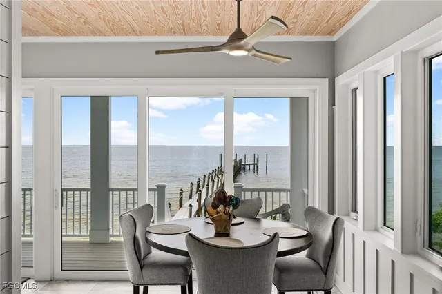 a large white kitchen with a large window and stainless steel appliances