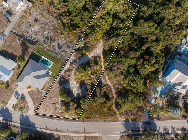 an aerial view of ocean and residential houses with outdoor space