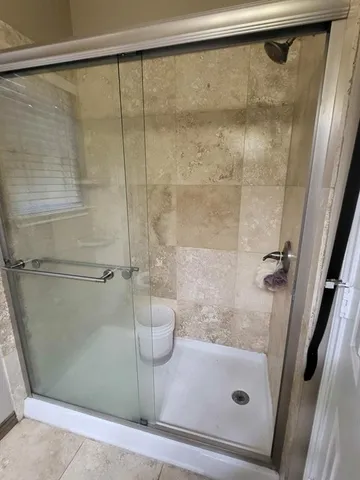a bathroom with a glass shower door