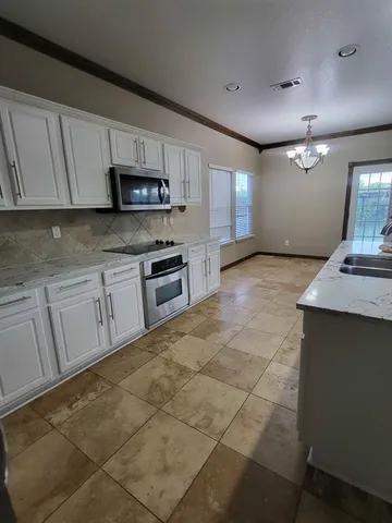 a view of kitchen with granite countertop cabinets and sink