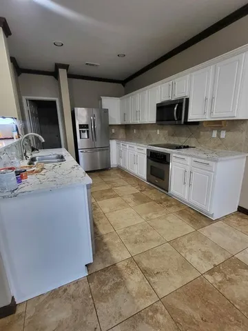 a kitchen with stainless steel appliances granite countertop a sink stove and cabinets