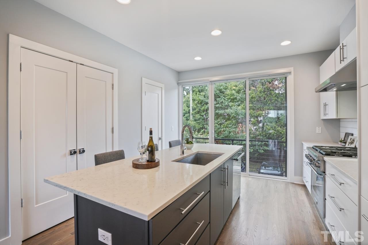 514 West South Street Raleigh, NC 27601 - Photo 11 of 41 a kitchen with a stove a sink a refrigerator and wooden cabinets