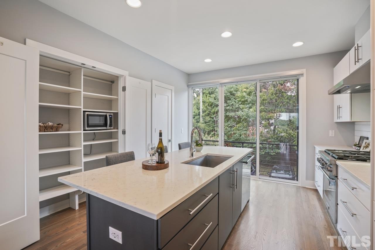 514 West South Street Raleigh, NC 27601 - Photo 12 of 41 a kitchen with a stove a sink a refrigerator and wooden cabinets