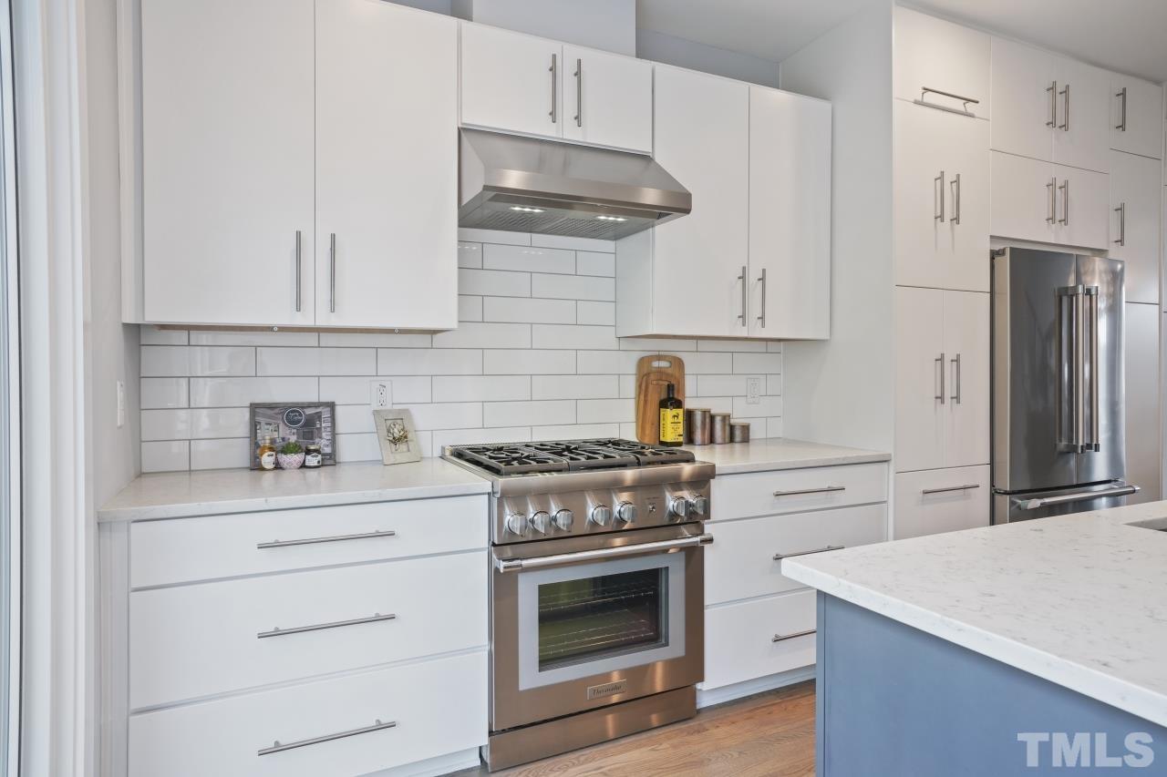 514 West South Street Raleigh, NC 27601 - Photo 13 of 41 a kitchen with granite countertop white cabinets and stainless steel appliances