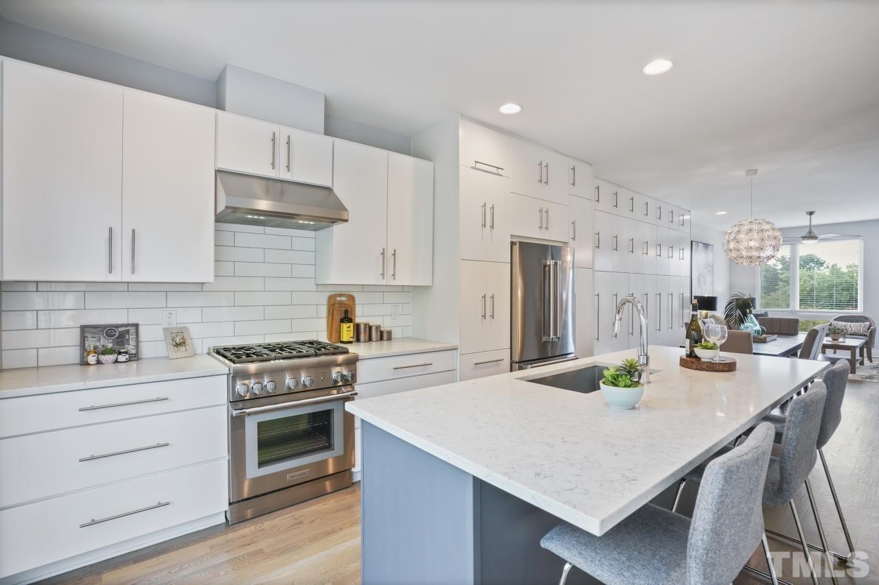 514 West South Street Raleigh, NC 27601 - Photo 14 of 41 a kitchen with stainless steel appliances a white table chairs stove and refrigerator