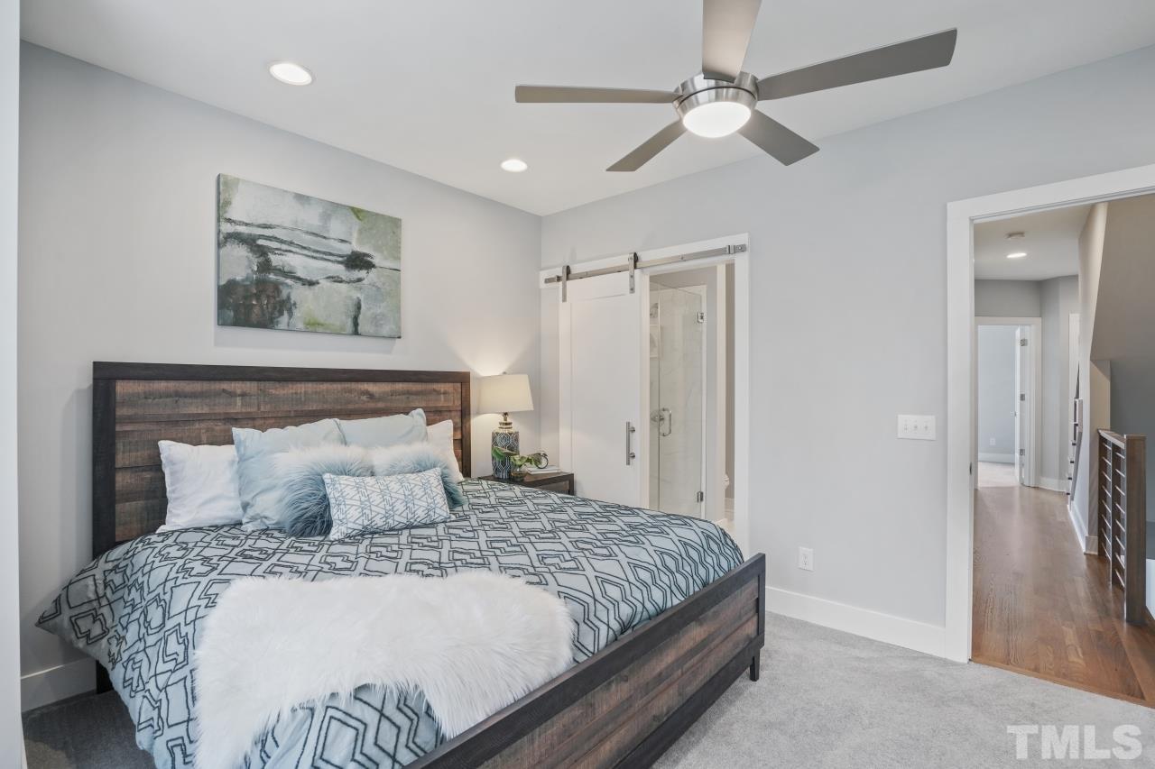 514 West South Street Raleigh, NC 27601 - Photo 23 of 41 a bedroom with a large bed and a chandelier