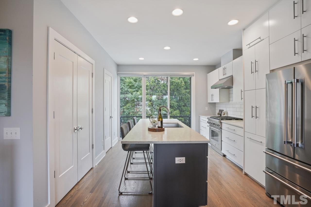 514 West South Street Raleigh, NC 27601 - Photo 8 of 41 a kitchen with a refrigerator a sink and white cabinets