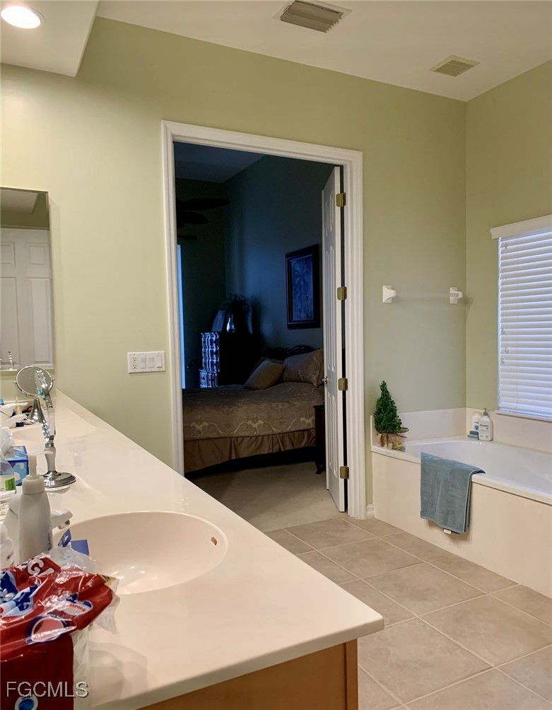 9053 Prosperity Way Fort Myers, FL 33913 - Photo 13 of 27 a en suite bathroom with a sink and a large mirror