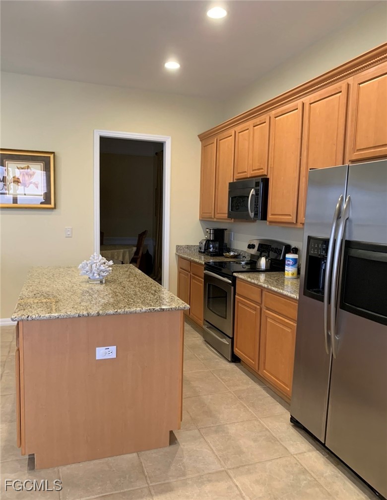 9053 Prosperity Way Fort Myers, FL 33913 - Photo 7 of 27 a kitchen with granite countertop a refrigerator and a stove top oven