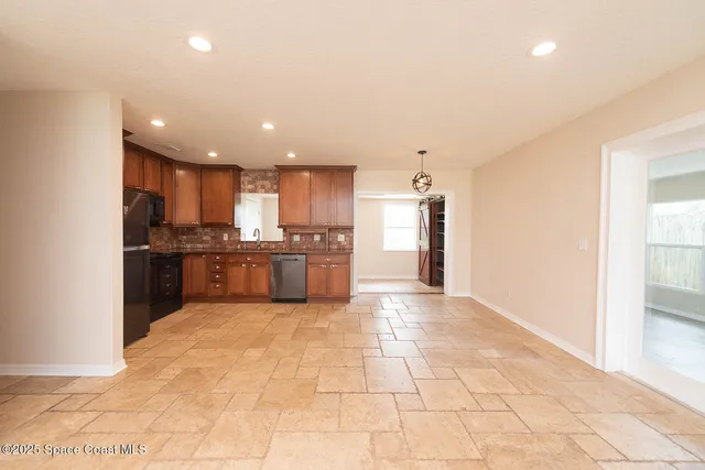 a view of kitchen with kitchen island microwave and cabinets