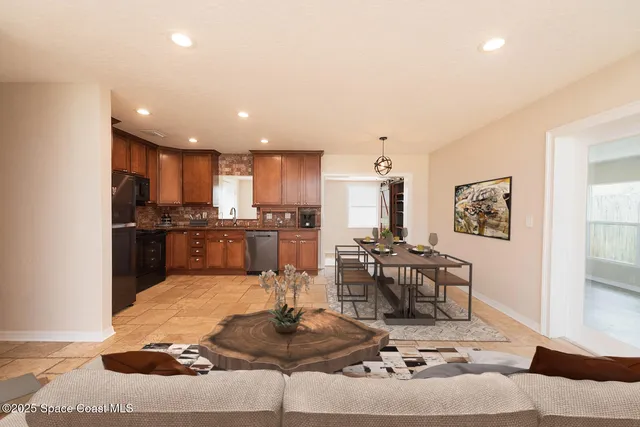 a living room with kitchen island furniture and a view of kitchen