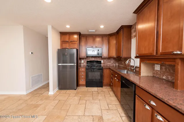 a kitchen with stainless steel appliances granite countertop a refrigerator and a sink