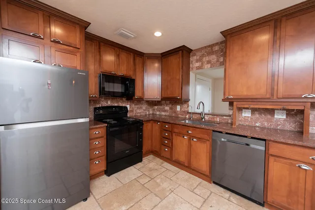 a kitchen with granite countertop stainless steel appliances and wooden cabinets