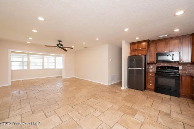 a view of a kitchen with a sink and a refrigerator