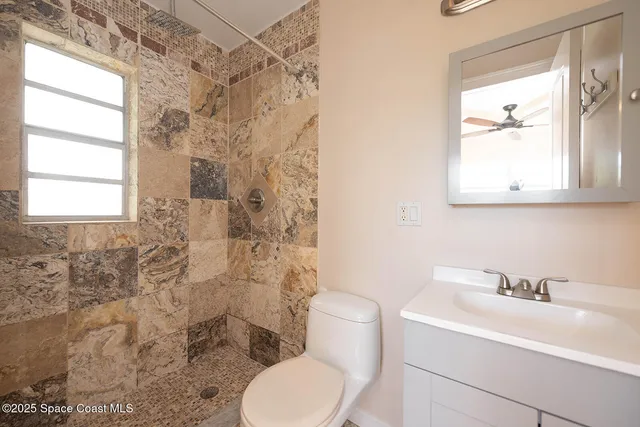 a bathroom with a sink toilet a mirror and shower