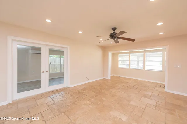 a view of an empty room and a ceiling fan