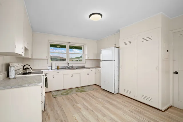 a kitchen with granite countertop white cabinets and white appliances
