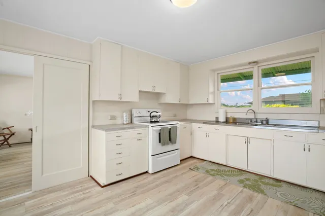 a kitchen with granite countertop white cabinets and white appliances