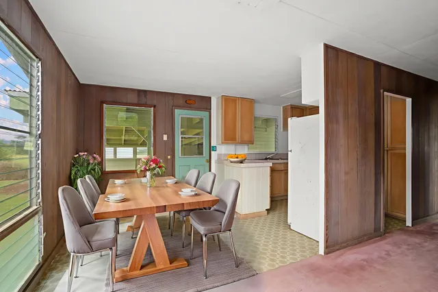 a dining room with furniture and a floor to ceiling window