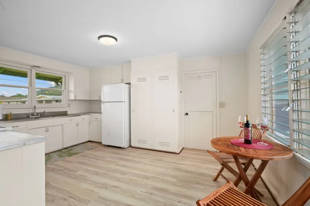 a kitchen with stainless steel appliances white cabinets and wooden floor