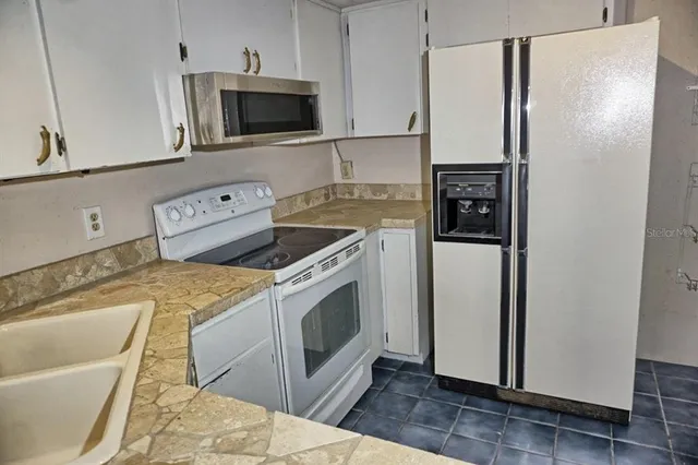 a kitchen with stainless steel appliances a stove a microwave and a refrigerator