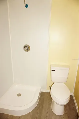 a white toilet sitting next to a shower
