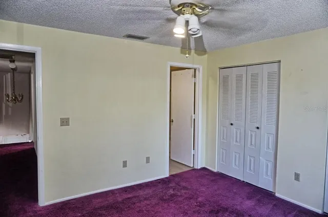 a view of empty room with a chandelier fan