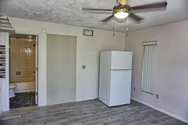 a view of a livingroom with wooden floor and ceiling fan
