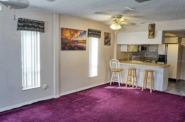 a livingroom with fireplace dining space and windows
