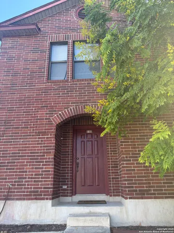 a front view of a house with a tree