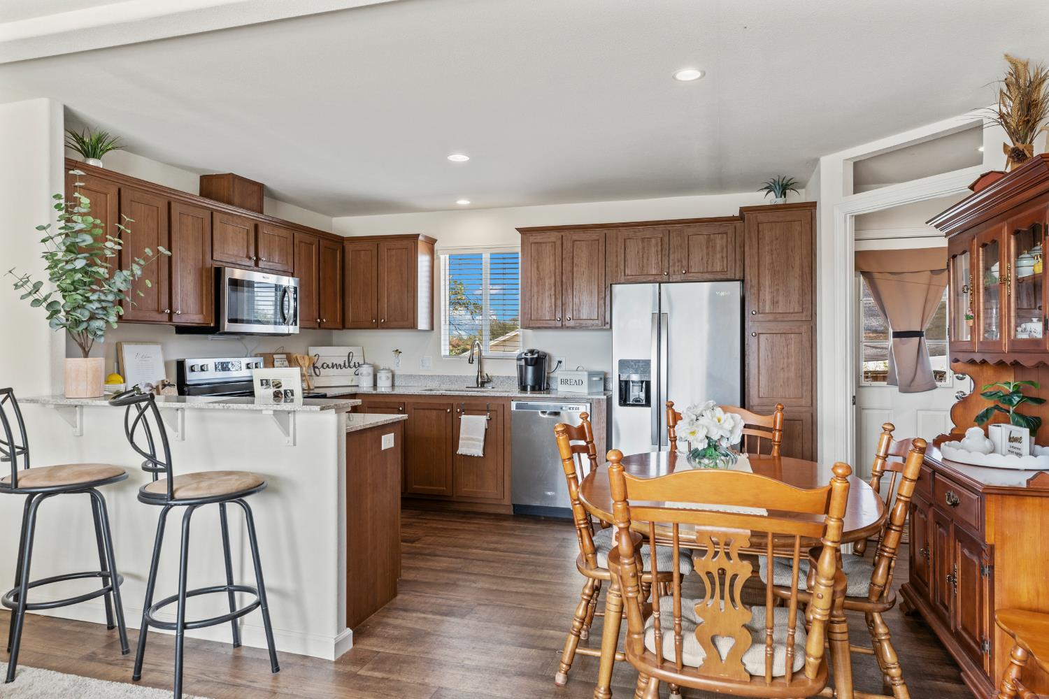 16120 Jacksonville Road Jamestown, CA 95327 - Photo 12 of 30 a kitchen with stainless steel appliances granite countertop a dining table chairs refrigerator sink and cabinets