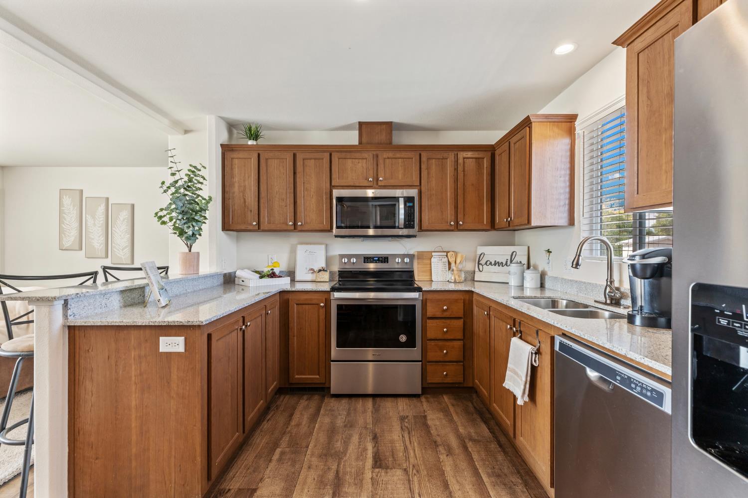16120 Jacksonville Road Jamestown, CA 95327 - Photo 13 of 30 a kitchen with stainless steel appliances granite countertop a stove a sink dishwasher and a microwave oven with wooden floor