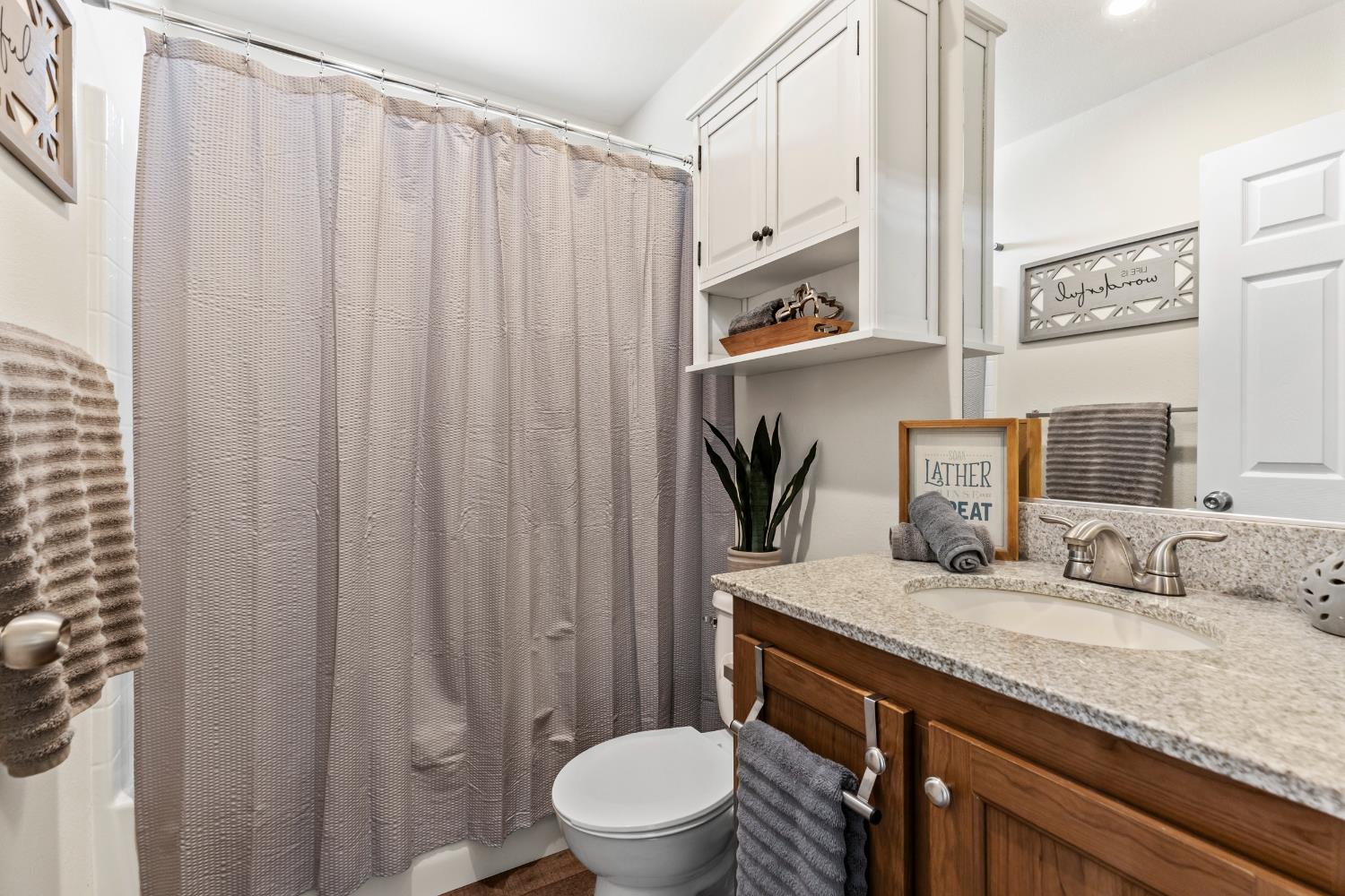 16120 Jacksonville Road Jamestown, CA 95327 - Photo 18 of 30 a bathroom with a granite countertop sink a toilet and a mirror