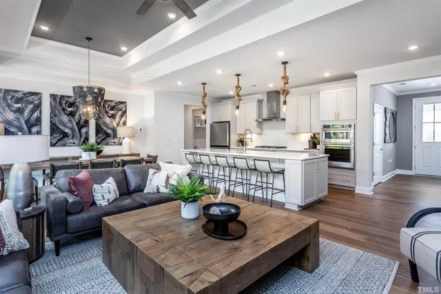 a living room with stainless steel appliances furniture and a kitchen view