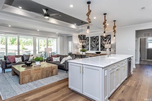 a view of a kitchen counter top space a sink wooden floor and windows