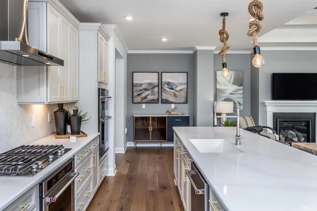 a kitchen with stove a sink and a fireplace with wooden floor