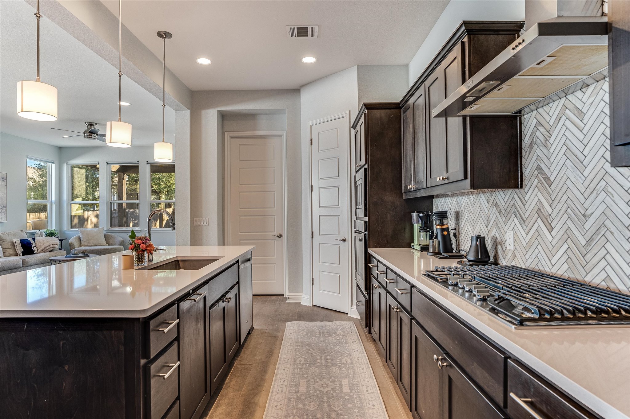 5205 Mandevilla Drive Austin, TX 78739 - Photo 8 of 20 a kitchen with kitchen island granite countertop a sink stove and cabinets