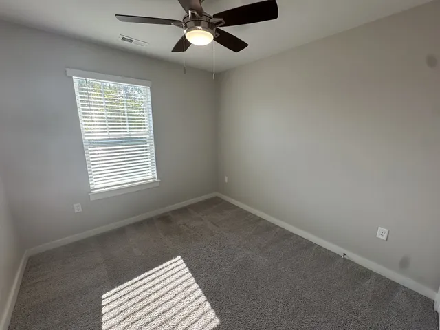 an empty room with a window and a fan