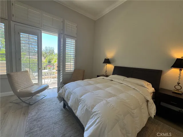 a bedroom with a large bed and wooden floor