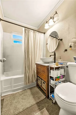 a bathroom with a sink a toilet and a shower curtain
