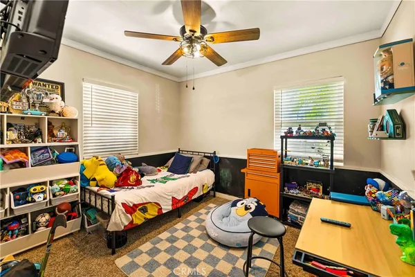 a bedroom with furniture a rug toys and a window