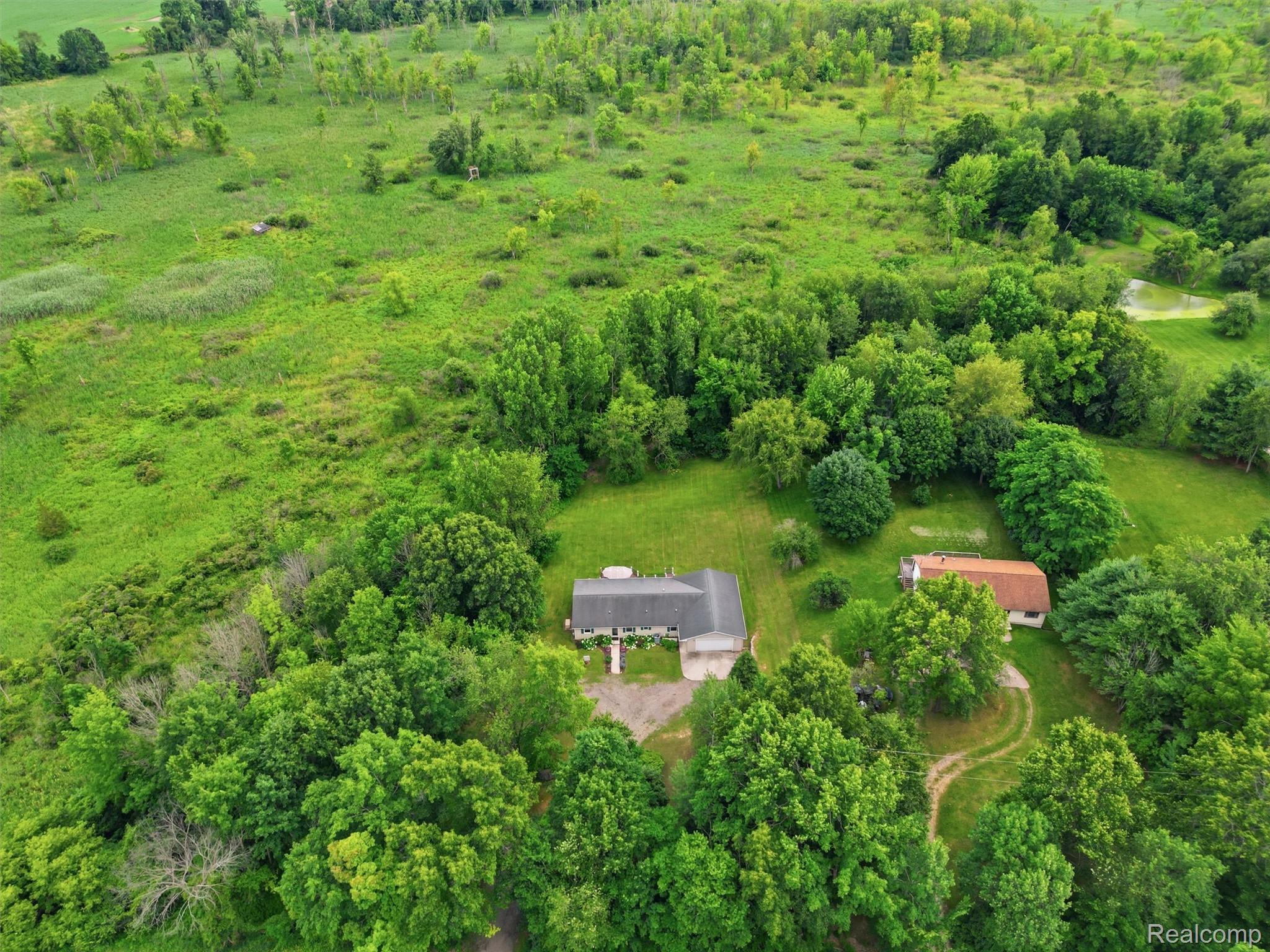 5003 Mason Road Howell, MI 48843 - Photo 56 of 59 Expansive green landscape featuring two residential structures and mature trees