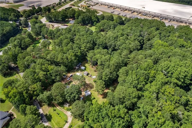 an aerial view of a house with a lush green forest