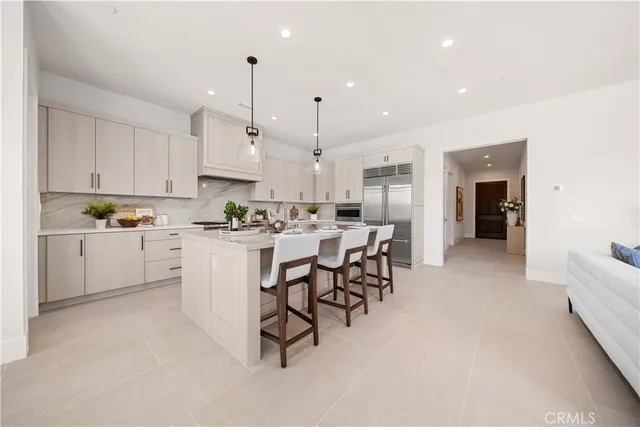 a kitchen with white cabinets and chairs