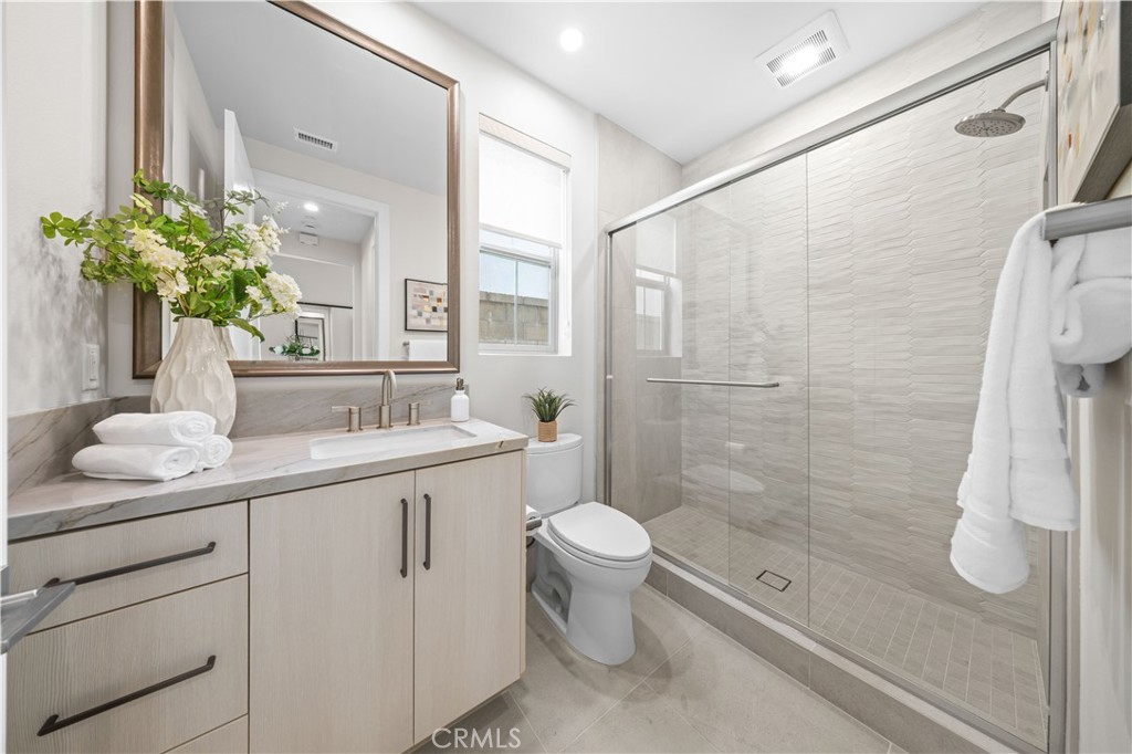 122 Mossvine Irvine, CA 92618 - Photo 17 of 44 a bathroom with a granite countertop sink a toilet and shower
