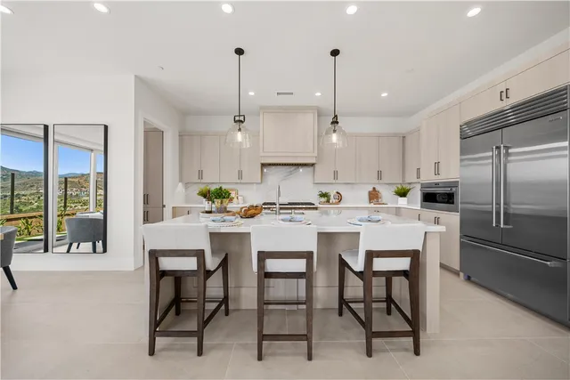 a kitchen with kitchen island a dining table chairs and white cabinets