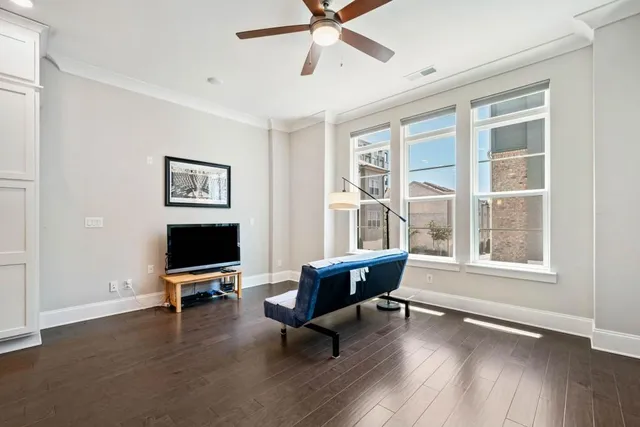 a living room with furniture and a flat screen tv with wooden floor