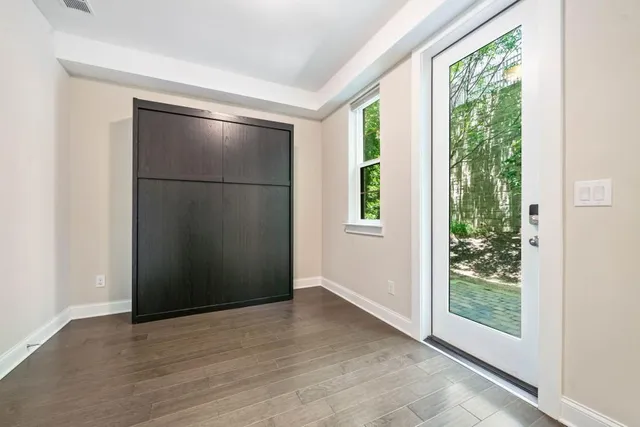 an empty room with wooden floor and windows