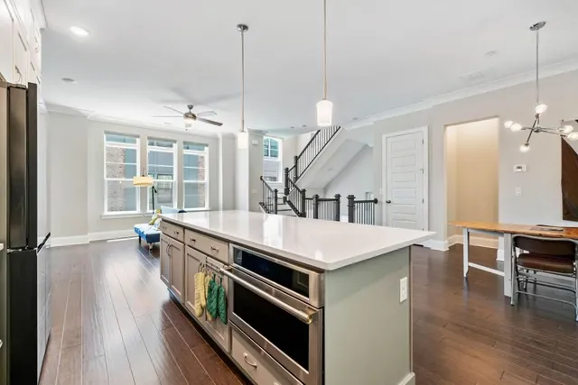 a kitchen with stainless steel appliances a stove a sink with wooden floor