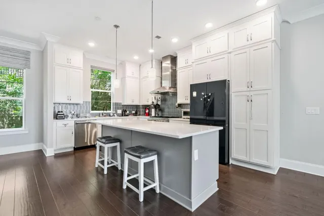 a kitchen with a refrigerator a sink and white cabinets